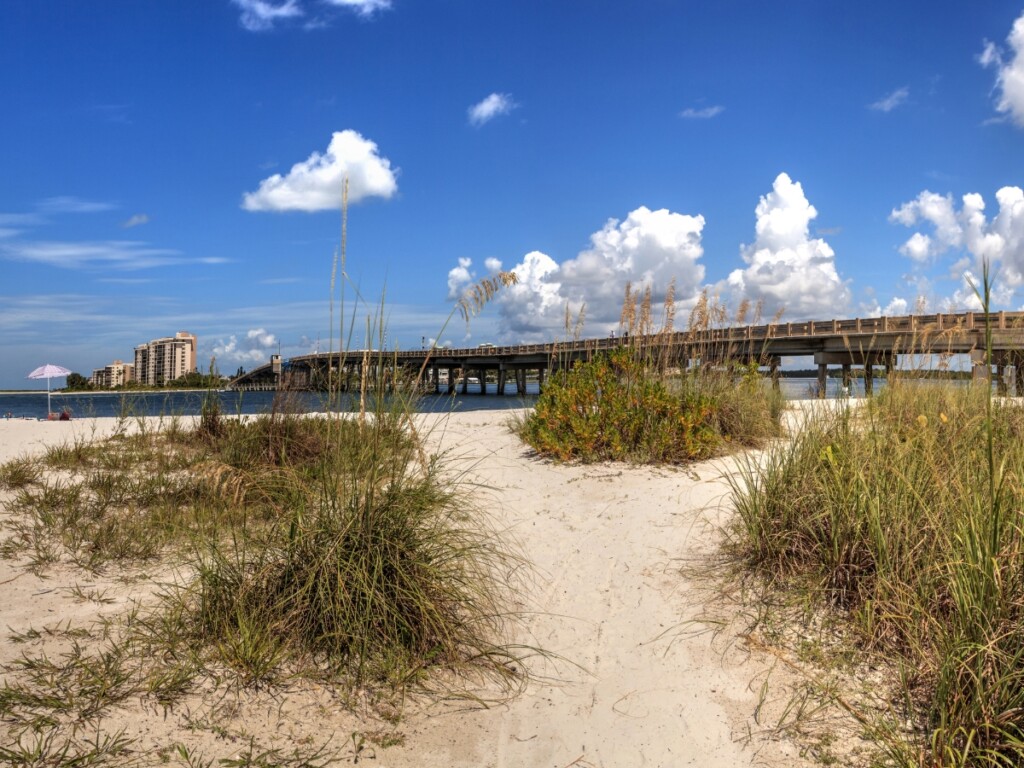 sandy pathway on lovers key beach with bridge in background